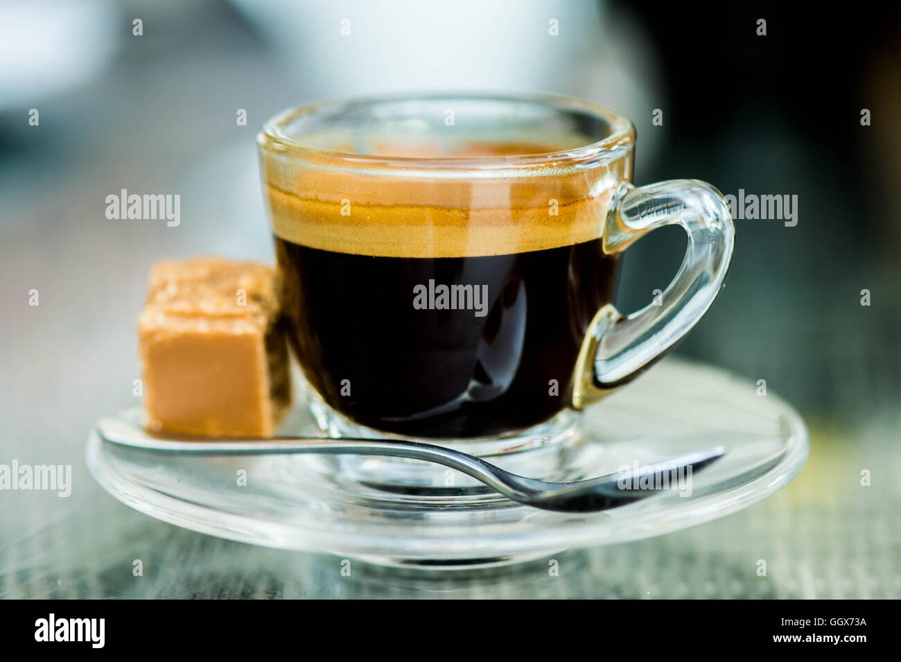 Beginnen Sie den Tag mit einem frisch gebrühten oder Tasse starken Erfrischende Single Shot Espresso in ein Glas Schale mit Fudge auf dem Tisch und keine Leute Stockfoto