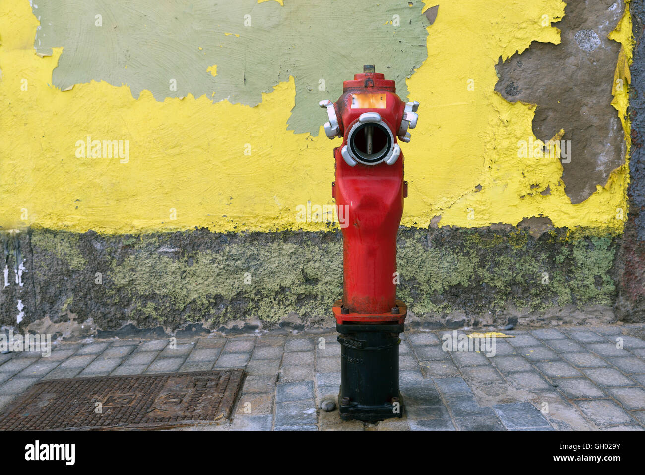Eine Nahaufnahme zu einem roten Hydranten in der Nähe einer Wand Stockfoto