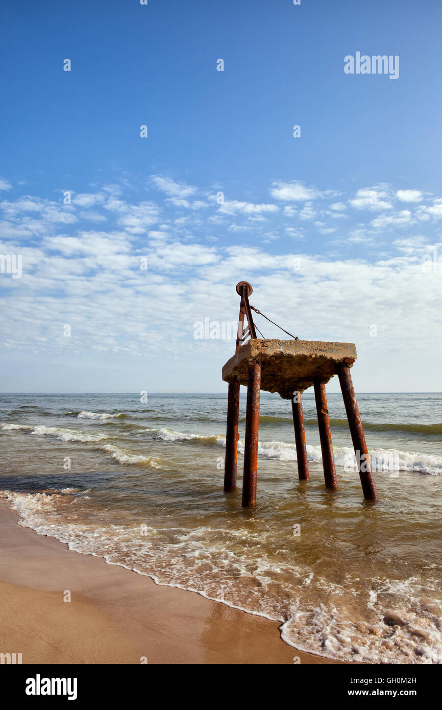 Verlassene Kran am Ufer der Ostsee in Polen, Betonplattform, alte Struktur auf rostigen Metallbeinen Stockfoto