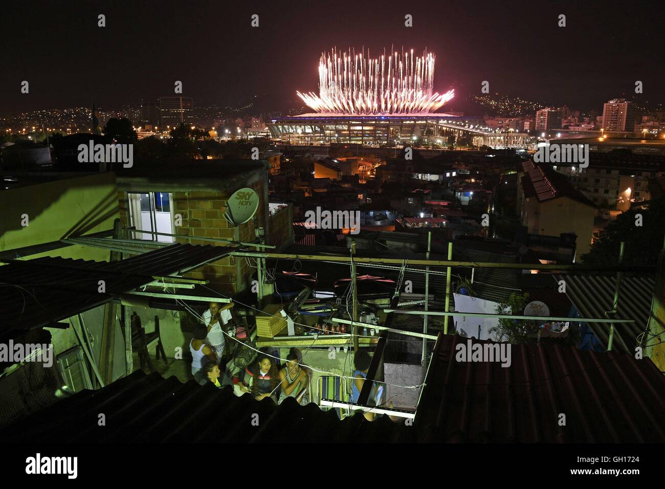 (160807) - RIO DE JANEIRO, 7. August 2016 (Xinhua)--Menschen sehen Feuerwerk explodiert über das Maracana-Stadion in Favela Mangueira während der Eröffnungsfeier der Rio 2016 Olympischen Spiele in Rio De Janeiro, Brasilien, 5. August 2016. Mangueira, eines der tausend Favelas in Rio De Janeiro, ist berühmt für seine Sambaschule Rios Haupt Liga 2016 Karneval Wettbewerb in diesem Jahr gewann. Etwa ein Fünftel der Einwohner der Stadt Leben in den Favelas von Gewalt und Armut überschattet. Obwohl mit niedrigem Einkommen und schlechtem Zustand leben, genießen Sie das Glück des Sports und der Herrlichkeit der Olympischen Spiele wie andere Brasilianer. ( Stockfoto