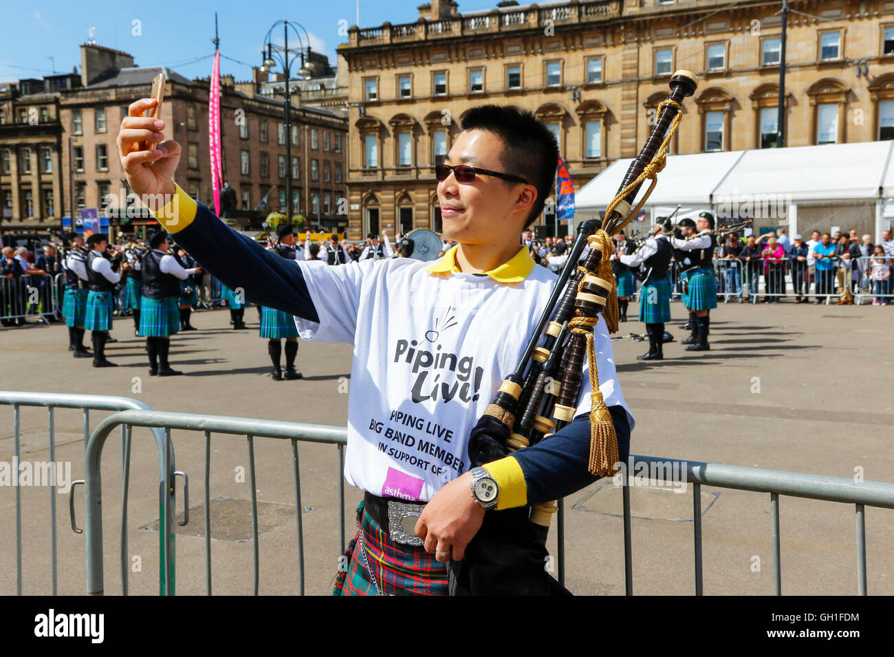 Glasgow, Schottland. 8. August 2016. Am ersten Tag der "Piping Live" statt ein jährliches Festival von Dudelsack-Musik an verschiedenen Orten in der ganzen Stadt, einige der internationalen teilnehmenden Pipebands kostenlose Konzerte in George Square gab. Die Pictue ist von KIERAN WAN die Pipe major der St Andrews Pipe Band, HONG KONG unter "Selfie" in George Square, während eine Pipe Band auftrat. Bildnachweis: Findlay/Alamy Live-Nachrichten Stockfoto