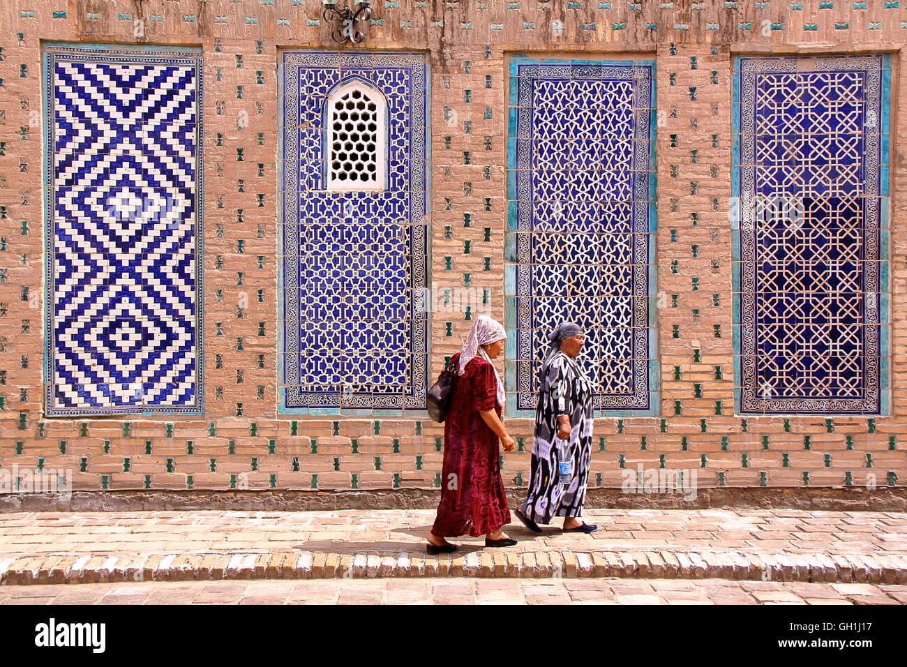 Usbekische Frauen gehen in den Hof des Palastes Tosh Hovli in Chiwa, Usbekistan Stockfoto