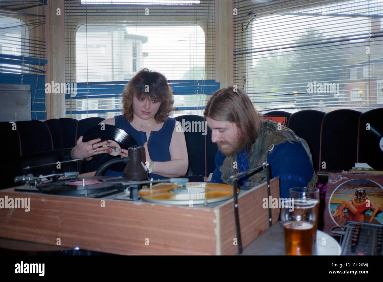 männliche und weibliche Disc-Jockeys verwenden traditionelle Decks zum Abspielen von Schallplatten in einer Kneipe während der 1980er Jahre England uk Stockfoto