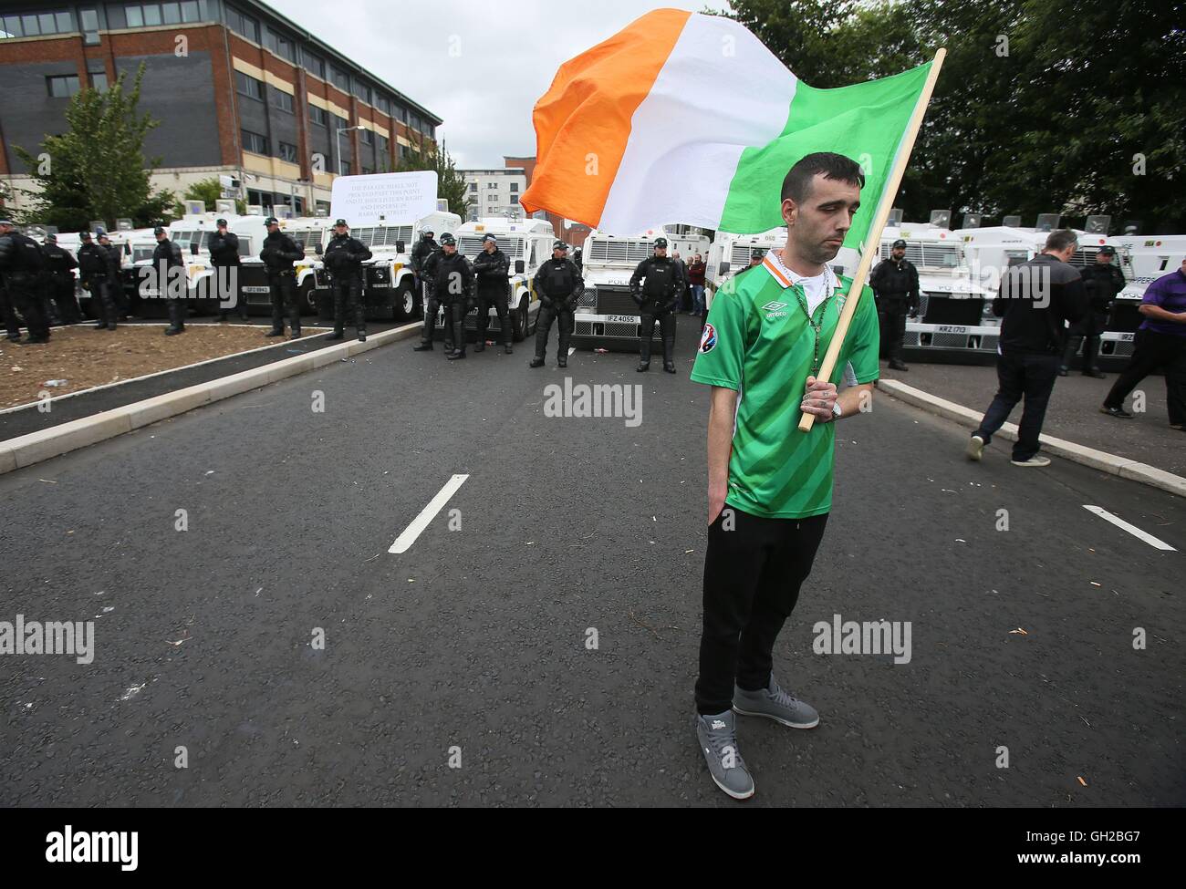 Ein einsamer Anhänger tragen eine irische Trikolore Follwing ein Anti-Internierung-Marsch, der an der Kreuzung der Divis und Barrack Street im Anflug auf die Innenstadt von der Polizei, die Durchsetzung einer Entschlossenheit Paraden Kommission beendet wurde. Stockfoto