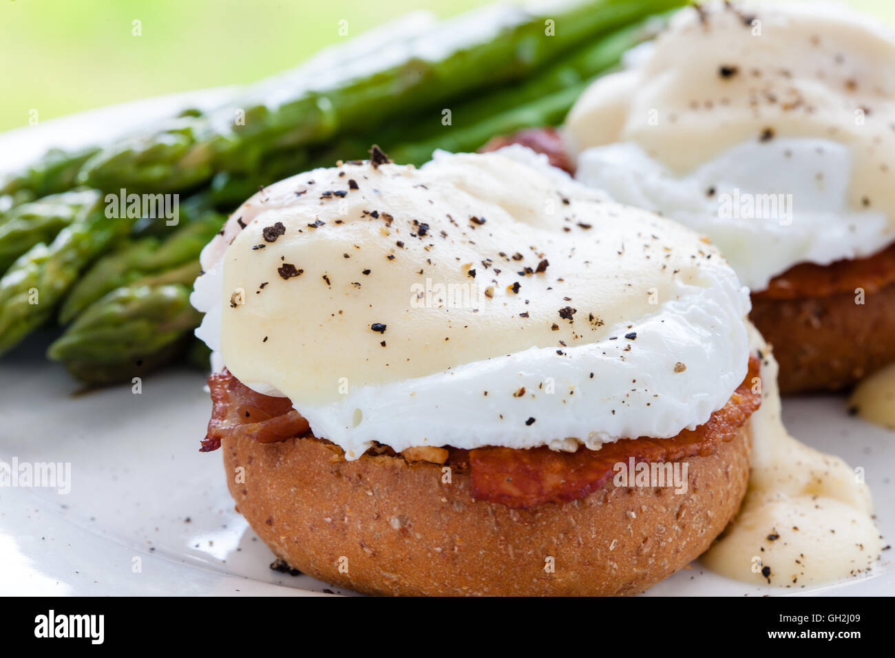 Spiegeleiern mit Speck und Käse Sauce auf Vollkornbrot bun Stockfoto