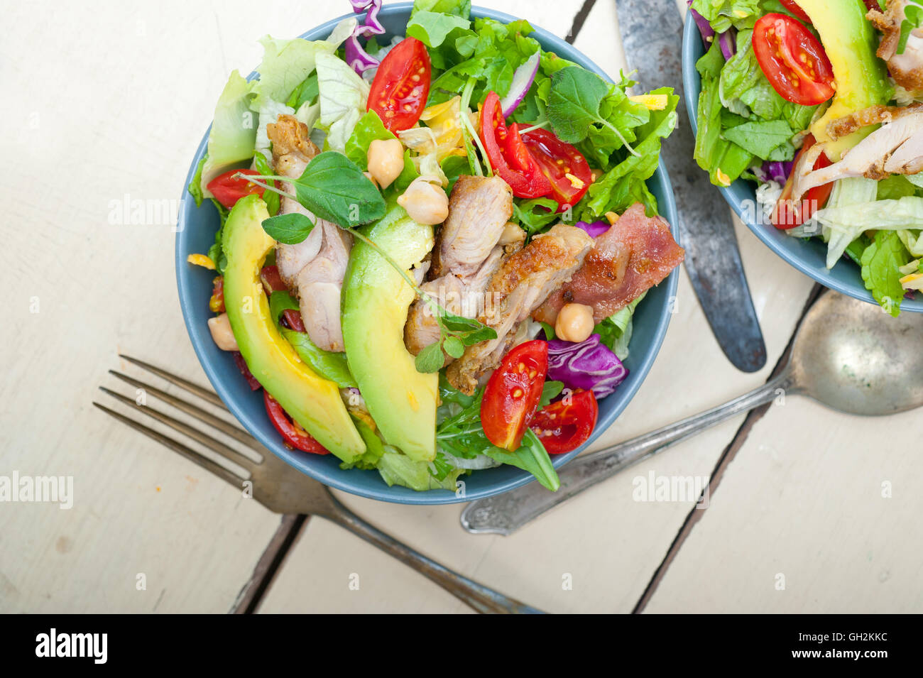 Frische und gesunde Hähnchen Avocado Salat über rustikalen Holztisch Stockfoto