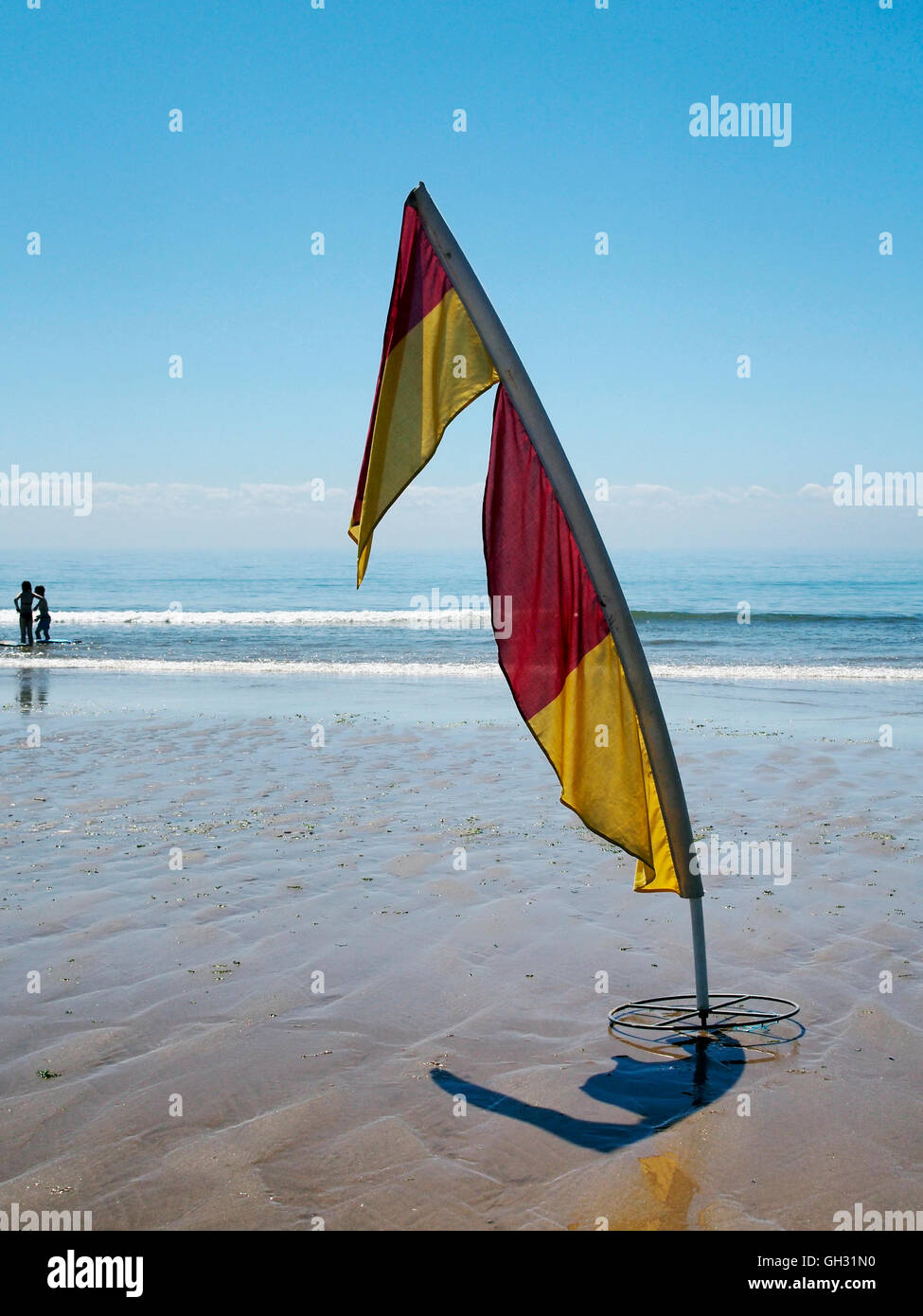 Rettungsschwimmer Markierungsfahnen zeigen patrouillierten gefährlich Strandbereich an drei Cliff Bay, Gower mit Menschen am Rand des Wassers. Stockfoto Rettungsschwimmer Markierungsfahnen zeigen patrouillierten gefährlich Strandbereich an drei Cliff Bay, Gower mit Menschen am Rand des Wassers. Stockfoto