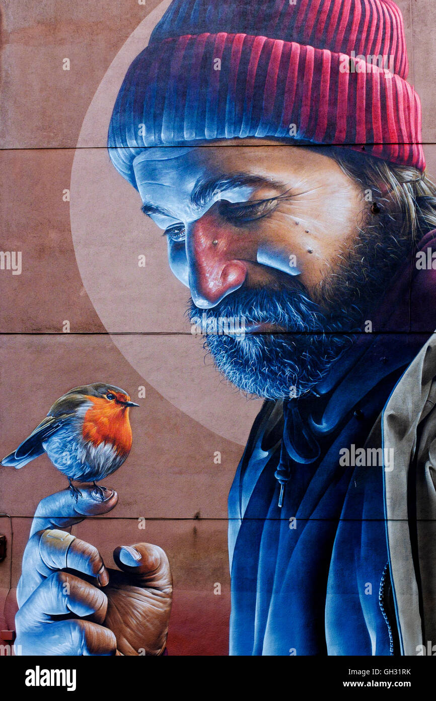 Wandmalerei an der Seite ein Mietshaus, Glasgow, Schottland, der ein Landstreicher hält ein Rotkehlchen Stockfoto