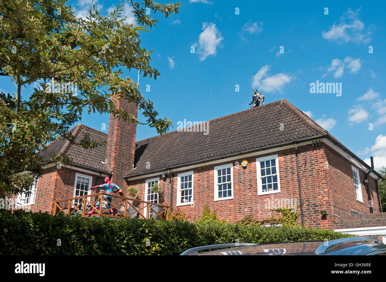 Lebensgroße Modelle von Batman und Spider-Man auf dem Dach und Balkon eines Hauses in Hampstead Stockfoto