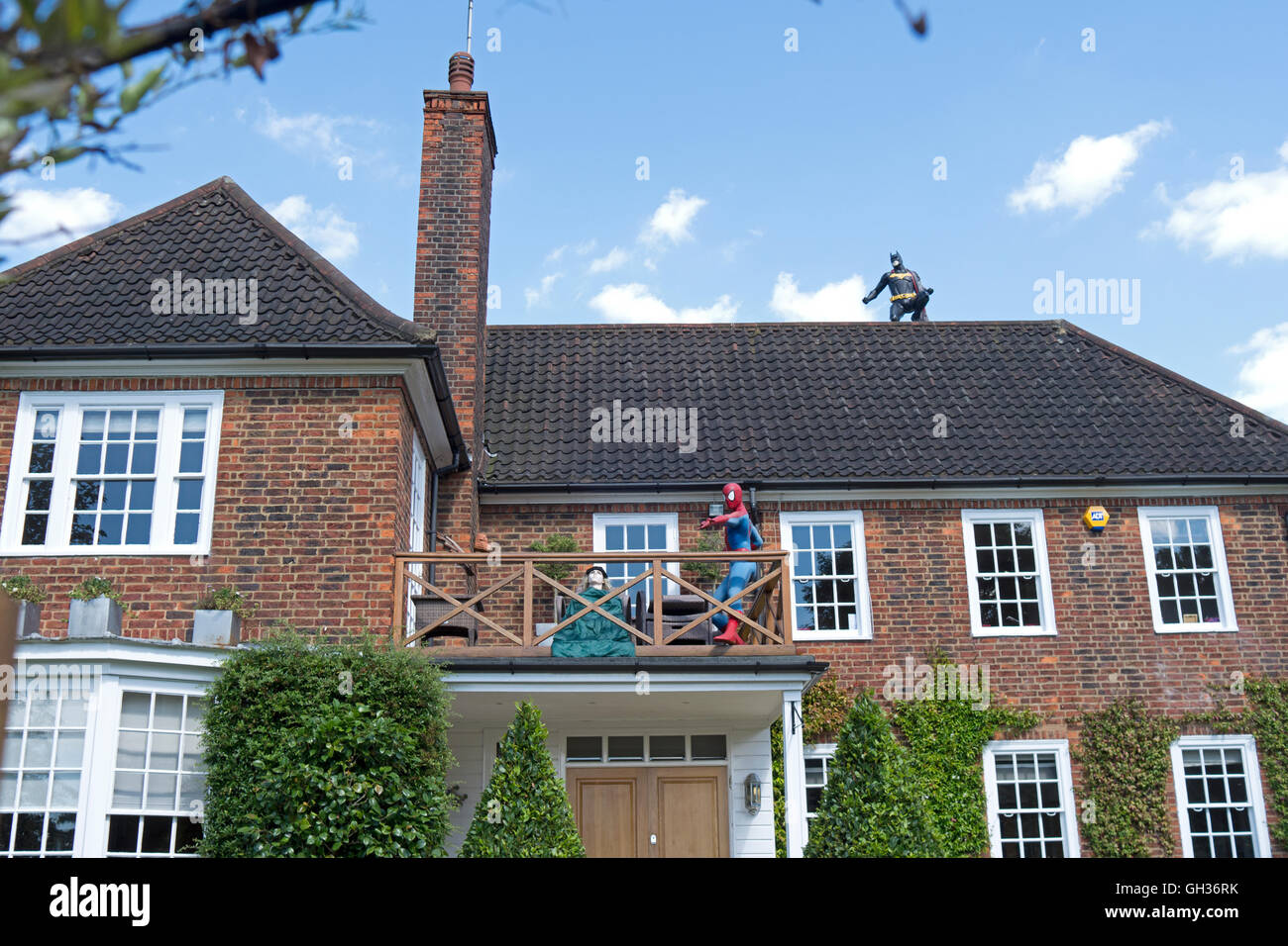 Lebensgroße Modelle von Batman und Spider-Man schmücken ein Haus in Hampstead Stockfoto