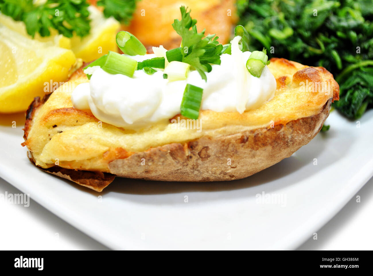 Ofenkartoffel serviert mit Sauerrahm und Frühlingszwiebeln Stockfoto