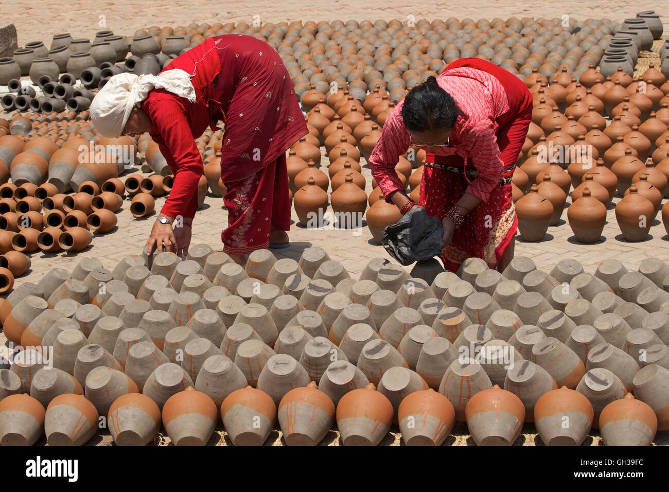 Frauen drehen Töpfe zum Trocknen in der Sonne, Potters Square, Bhaktapur, Nepal, Asien Stockfoto