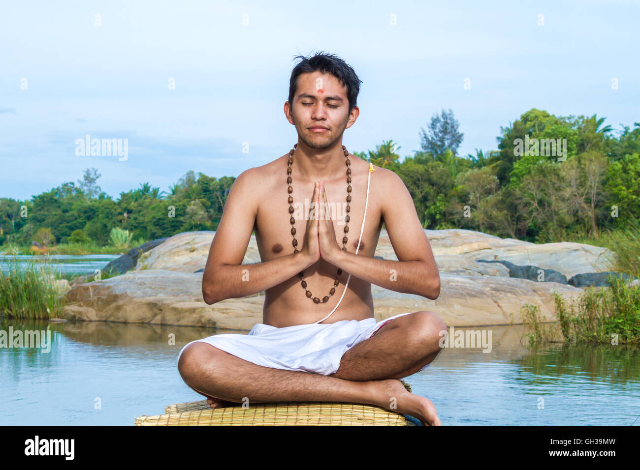 Ein junger Hindu Priester (Brahmanen) befindet sich im Gebet an einem Flussufer. Stockfoto