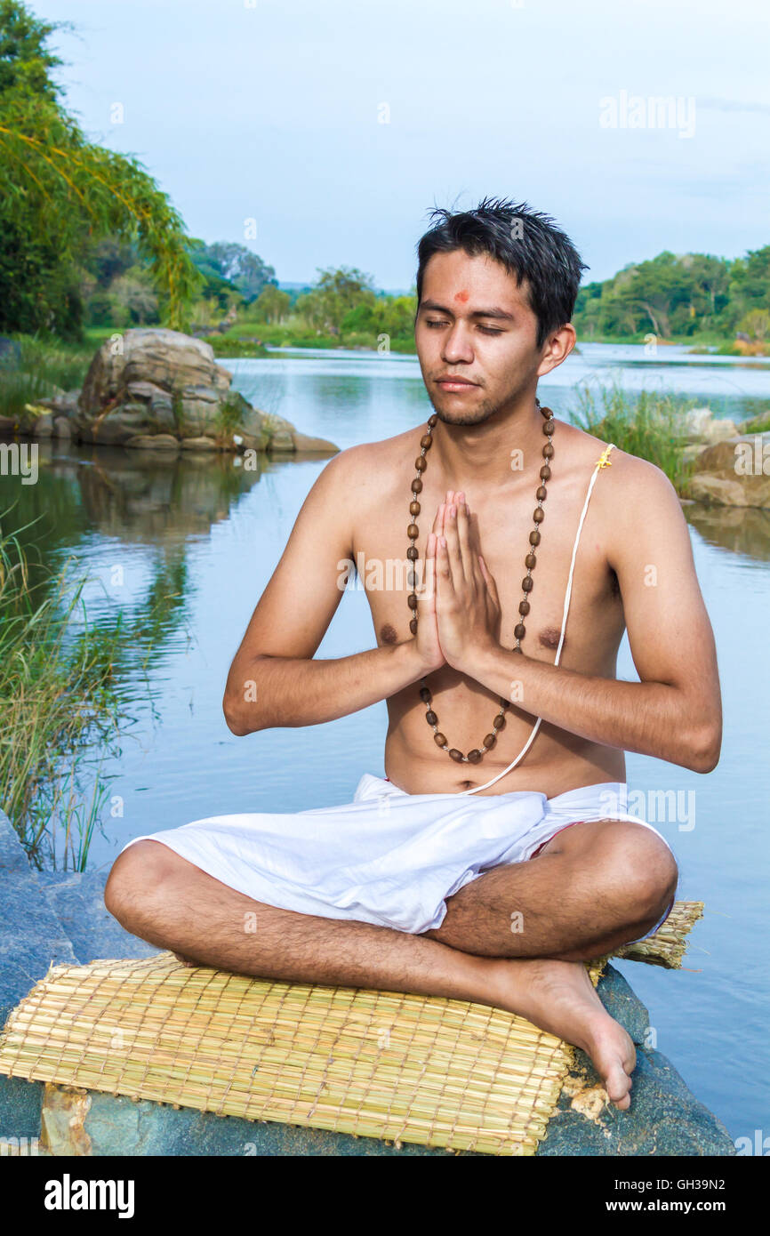Ein junger Hindu Priester (Brahmanen) befindet sich im Gebet an einem Flussufer. Stockfoto