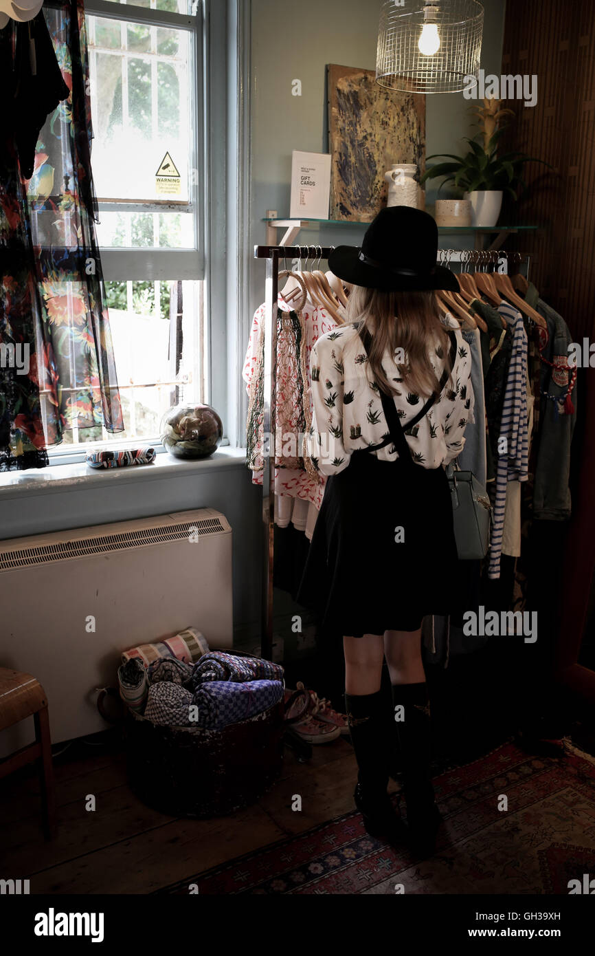 ein 12 Jahres altes Mädchen trägt einen schwarzen Hut in einem Vintage-Kleidung Shop durchsuchen Stockfoto