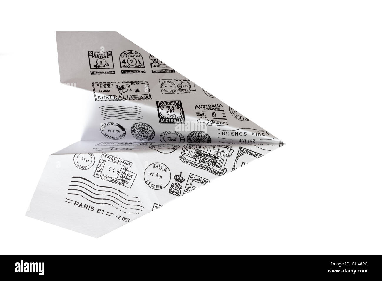 Papierflieger mit Post Briefmarken auf weißem Hintergrund Stockfoto