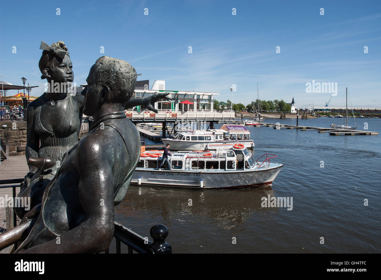 Bronzestatue "People Like Us" von John Clinch mit Blick auf den Innenhafen in Cardiff Bay Stockfoto