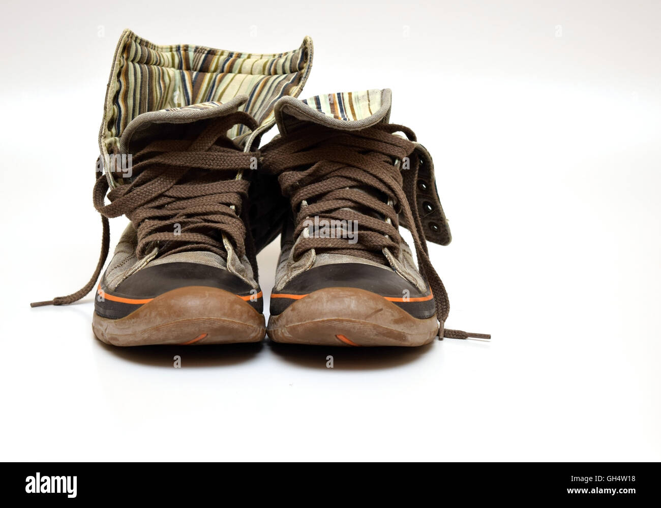 braune Turnschuhe mit Orangen Streifen auf weißem Hintergrund isoliert Stockfoto