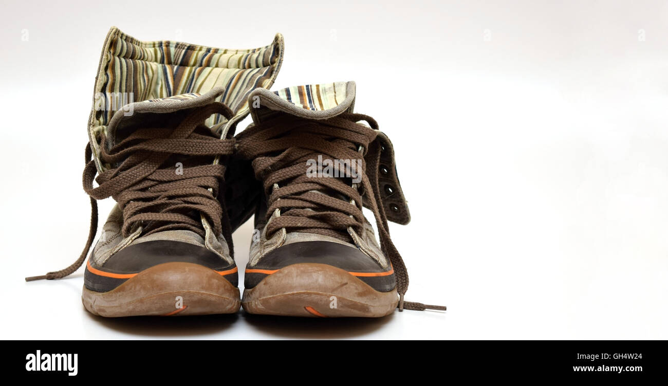 braune Turnschuhe mit Orangen Streifen auf weißem Hintergrund isoliert Stockfoto