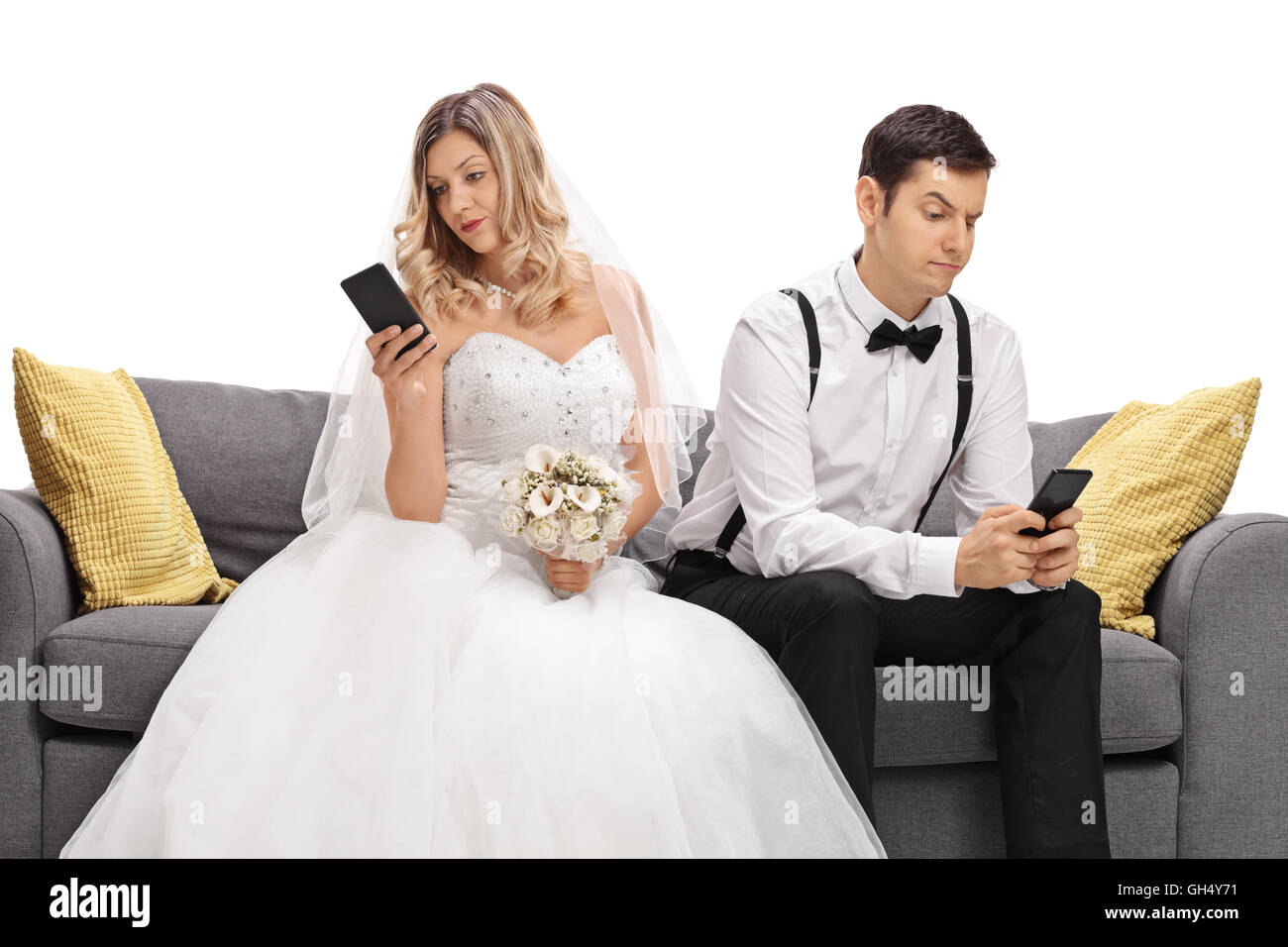 Junge Ehepaar sitzt auf einem Sofa mit Blick auf ihren Handys und ignorieren einander isoliert auf weißem Hintergrund Stockfoto