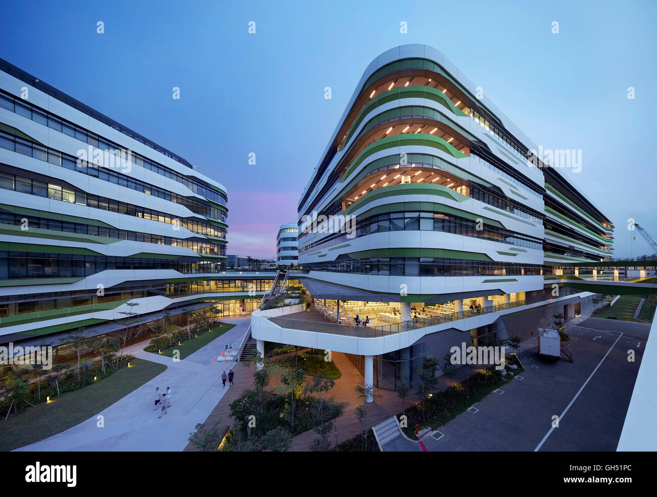 Blick über den Campus mit beleuchteten Innenräumen. Singapur-Hochschule für Technik und Design, Singapur, Singapur. Architekt: UNStudio, 2015. Stockfoto