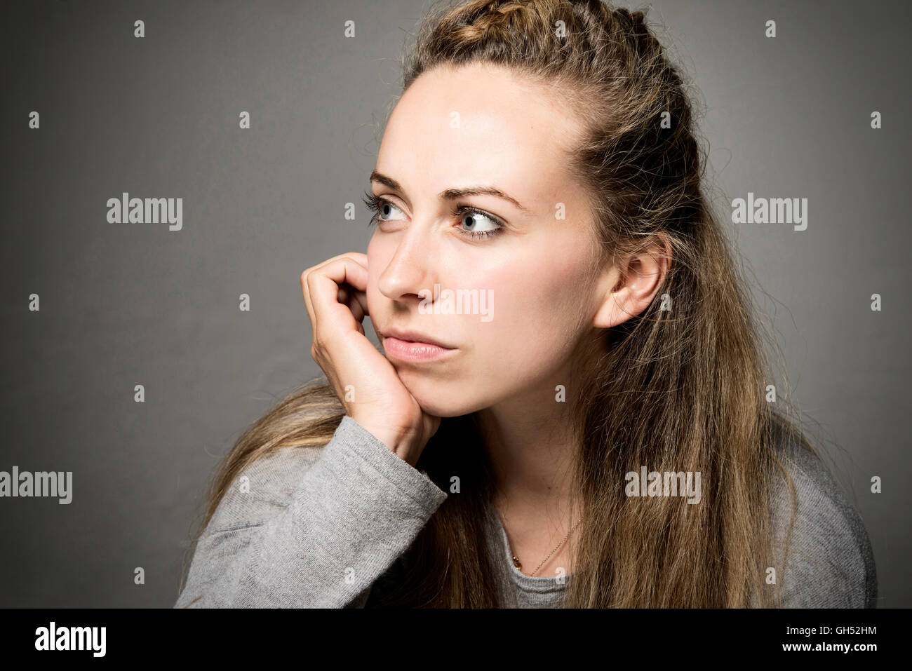 Junge Frau sucht traurig, traurig, nachdenklich Hand am Kinn auf den Abstand Nahaufnahme Stockfoto