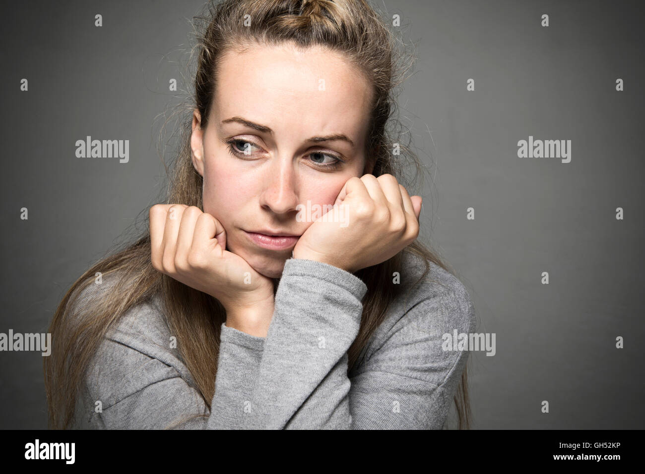 Junge Frau hautnah Bedrücktes Gesicht ruhen auf Hände suchen hoffnungslos in dem Abstand-Konzept Stockfoto