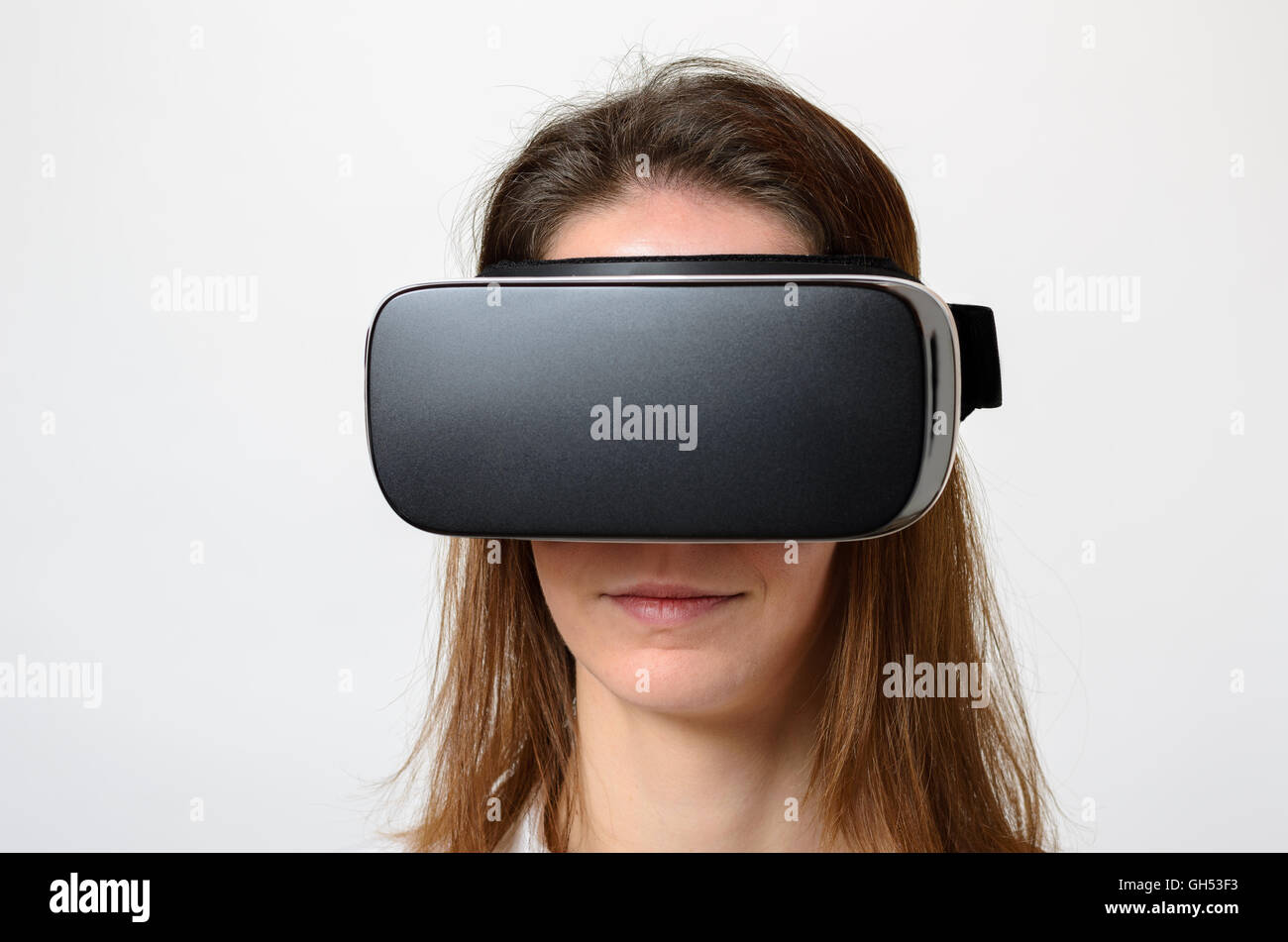 Nahaufnahme von ruhigen Frau braune Haare tragen virtuelle 3d Gerät auf Gesicht über grauen Hintergrund Stockfoto