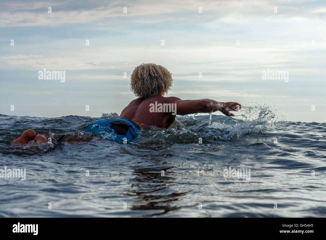 Surfer paddeln in den Ozean Stockfoto