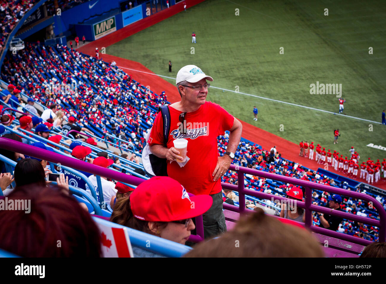 Ein Mann mit einem Bier sucht seinen Sitz am Canada Day im Rogers Centre in Toronto, Kanada. Stockfoto