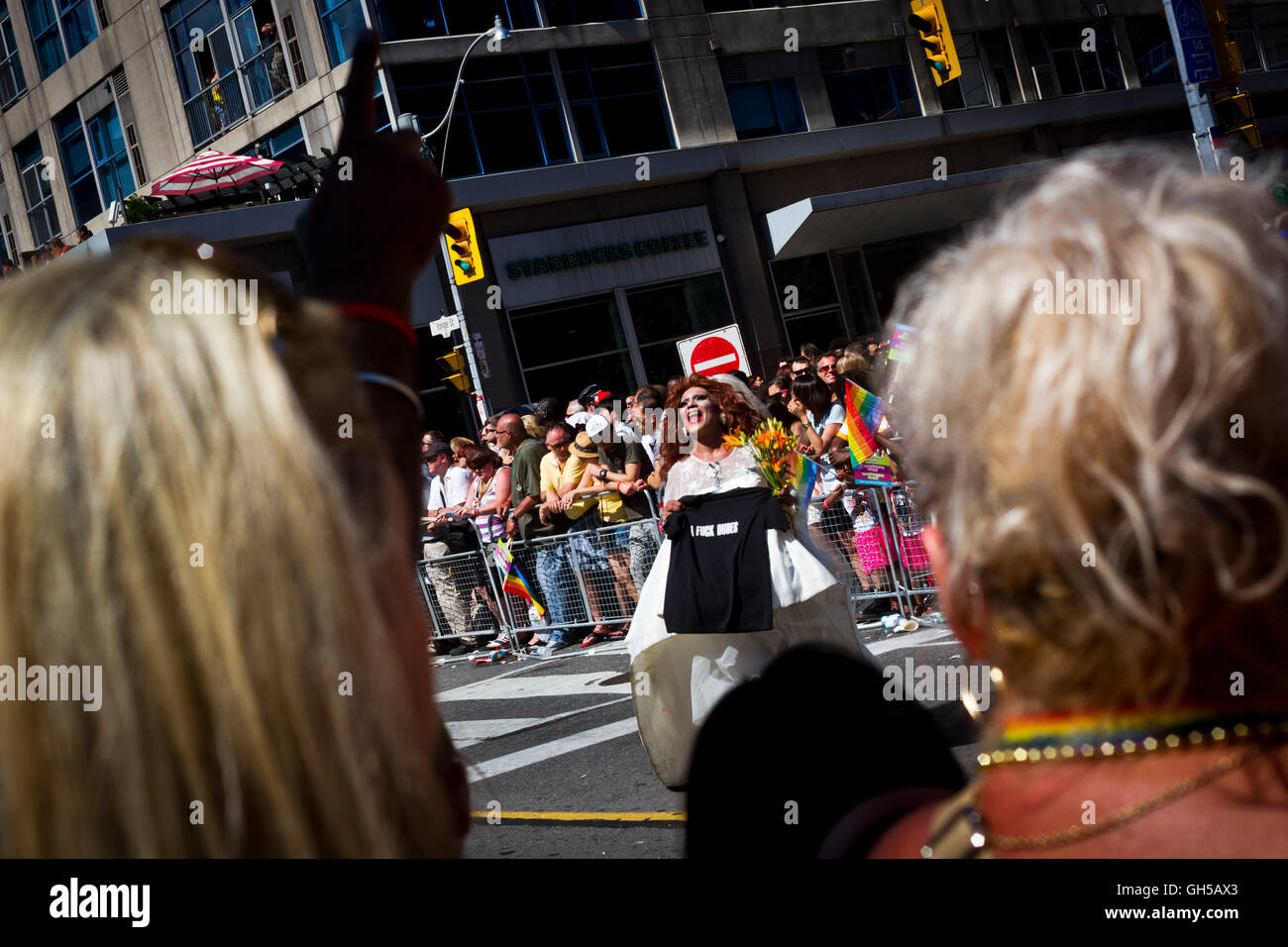 Ein Teilnehmer, der eine Hochzeit Kleid hält ein tshirt an der Pride Parade in Toronto, Kanada. Stockfoto