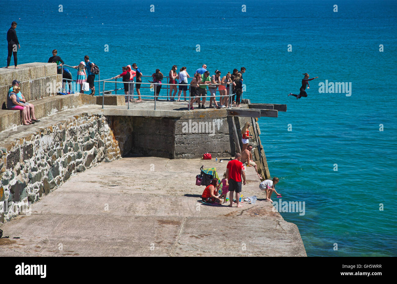 Kinder Tombstoneing von der Hafenmauer in St Ives in Cornwall Stockfoto