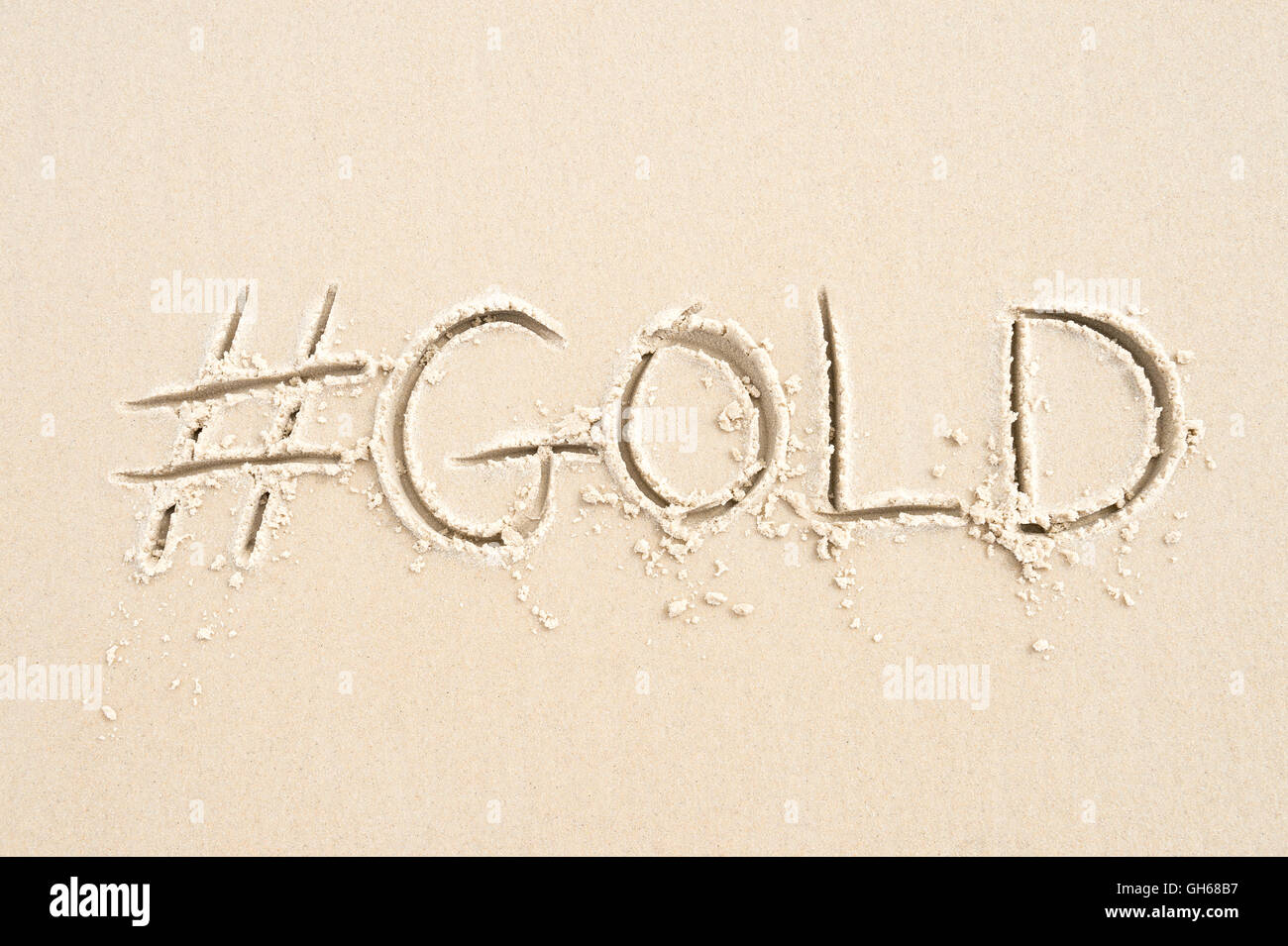 Hashtag-social Media-Nachricht für Gold geschrieben im Sand am Strand von Rio De Janeiro, Brasilien Stockfoto