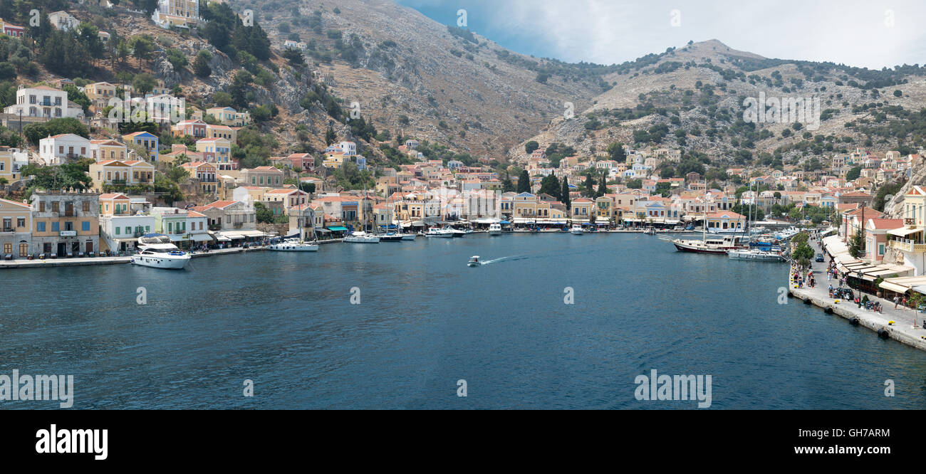 Panorama-Bild von Symi Stadt mit bunten Häusern auf dem Hügel, in der griechischen Insel Symi. Stockfoto