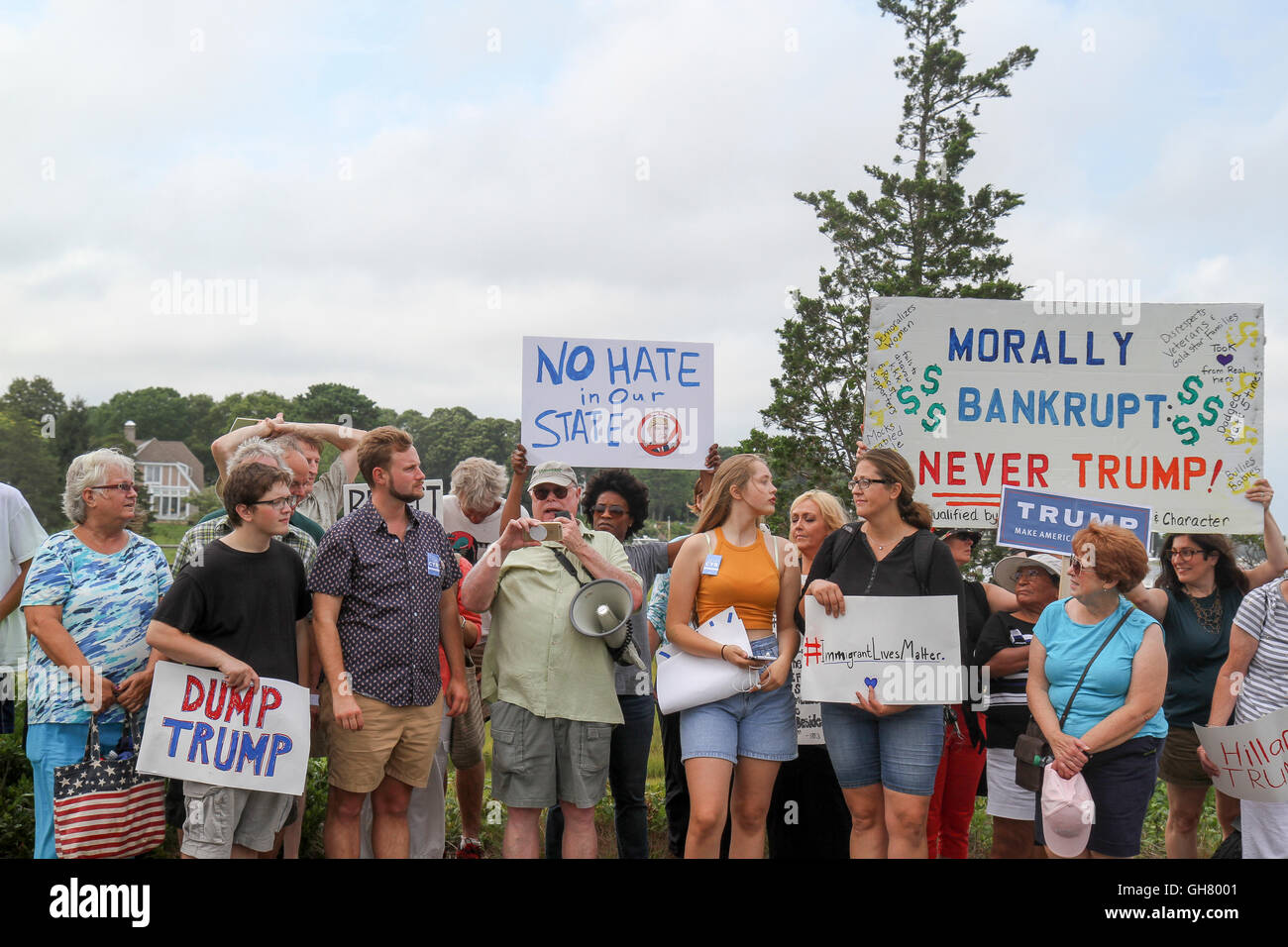 Osterville, Massachusetts, USA. 6. August 2016. Demonstranten halten Zeichen gegen Präsidentschaftskandidat Donald Trump, in der Nähe eine Spendenaktion Geschäftsmann, den William Koch für Trump gehostet wird. Bildnachweis: Susan Pease/Alamy Live-Nachrichten Stockfoto