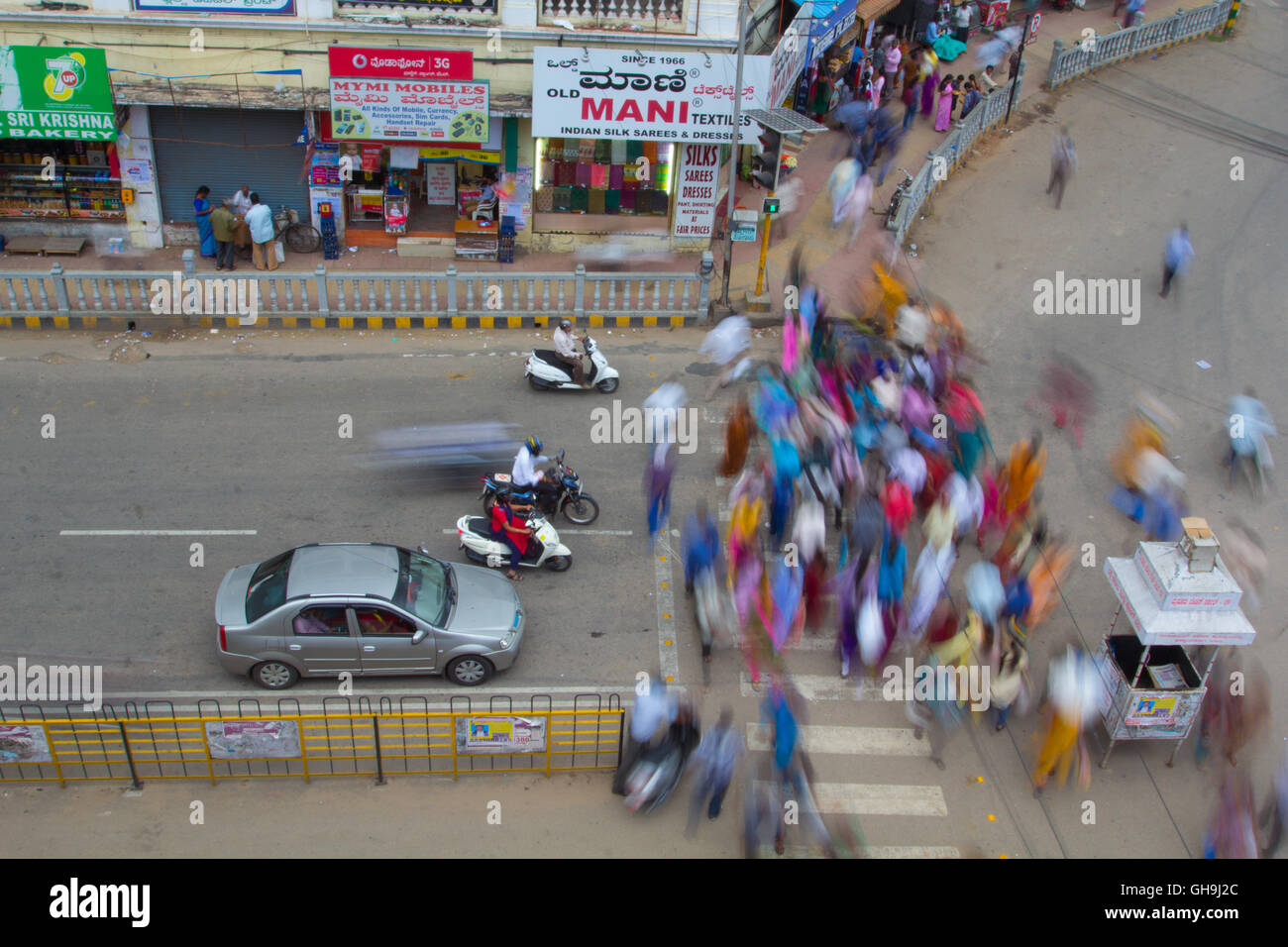 Menschen beim Überqueren der Straße in Indien. Eine Luftaufnahme. Stadt Mysore, Karnataka Stockfoto
