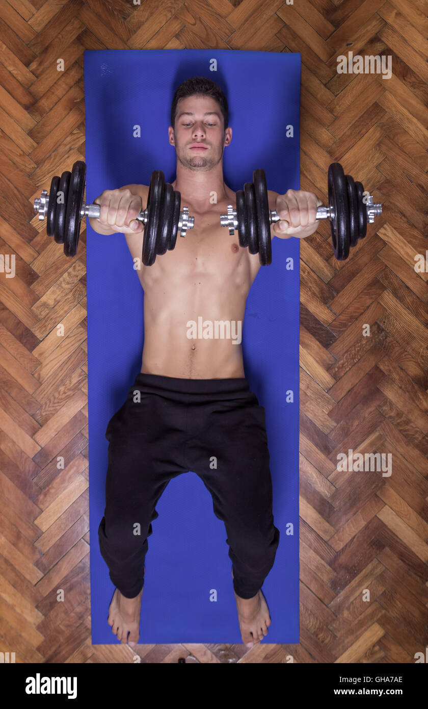 Junge fit starken Mann Ausübung Brust Hantel Muskeln Gewichte Stockfoto
