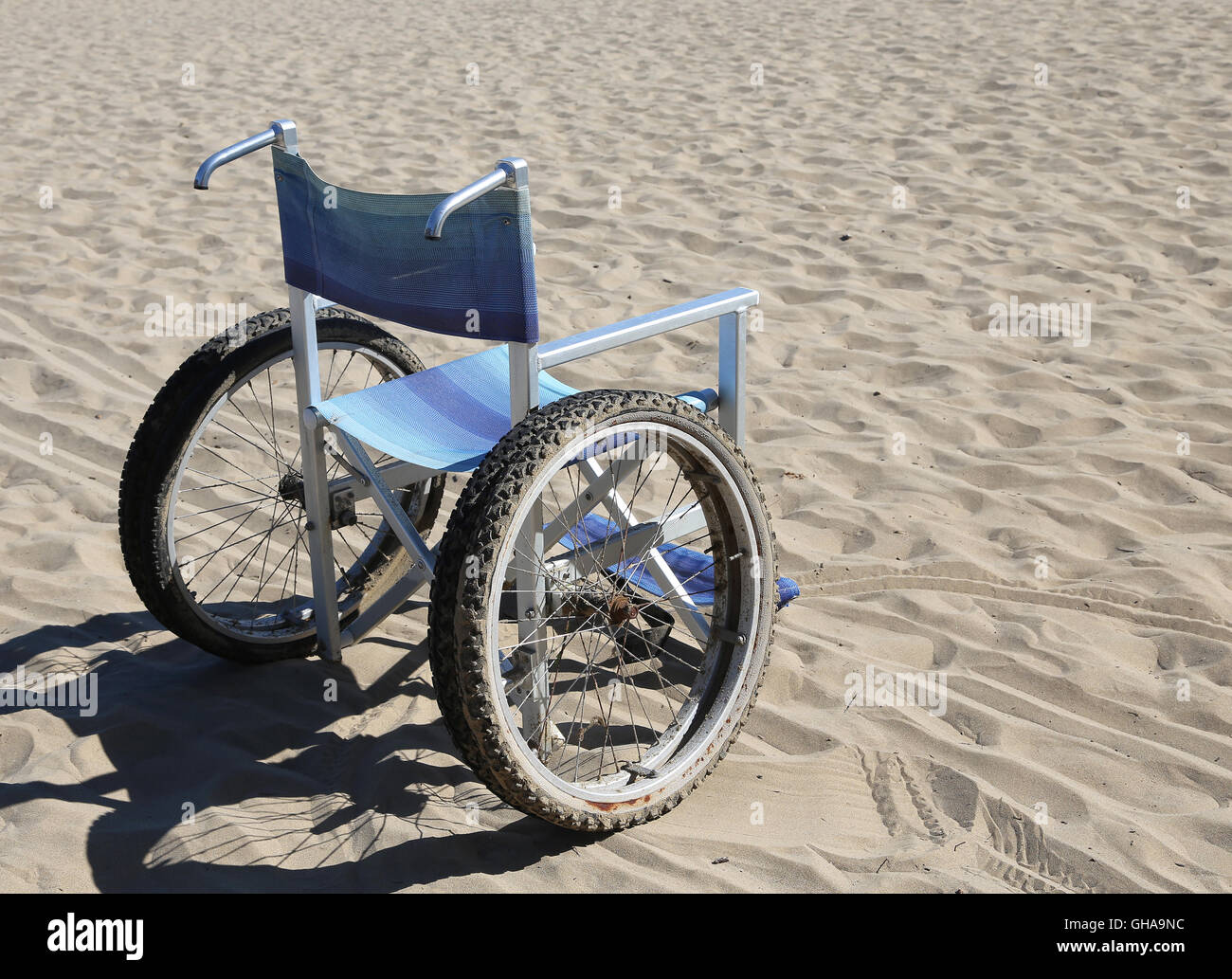 Rollstuhl auf dem Sand des Strandes im Sommer Stockfoto