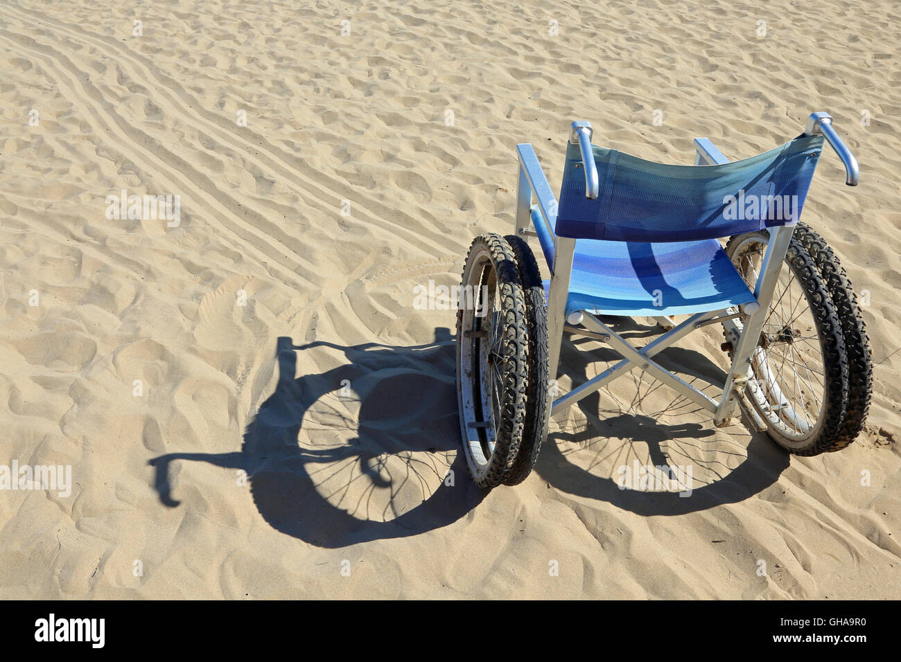 Aluminium Rollstuhl auf dem Sand des Strandes Stockfoto