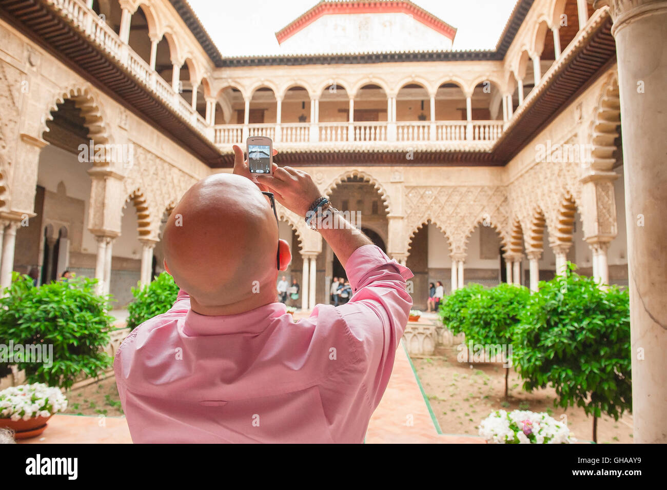 Sevilla Alcazar, Rückansicht eines Touristen, der ein Foto vom zentralen Innenhof des Alcazar (Patio de las Doncellas), Sevilla, Andalusien, Spanien macht. Stockfoto