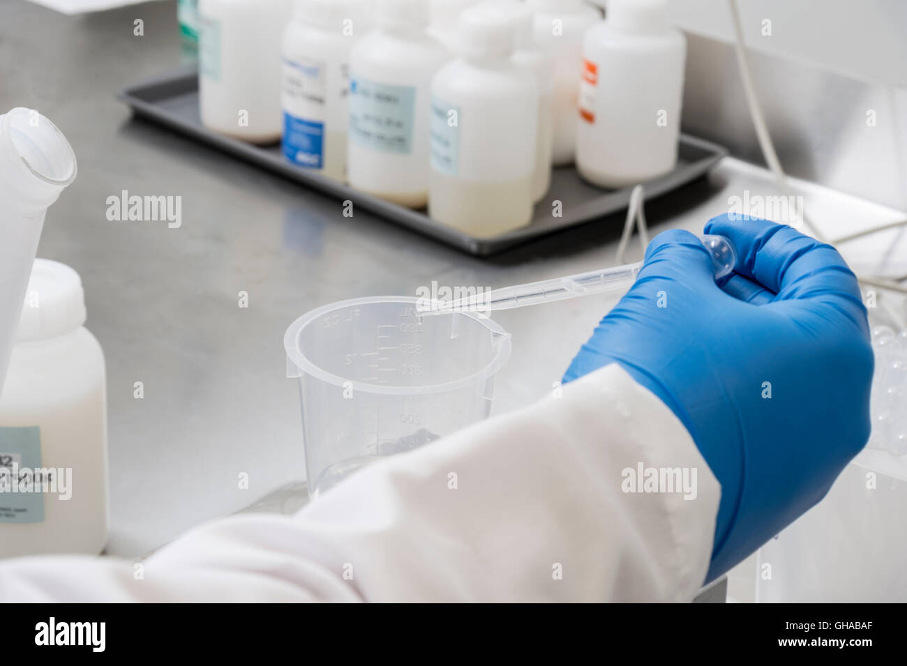 Lab Technician übergibt strömende Chemikalien im Becher zum Wiegen Messung Stockfoto