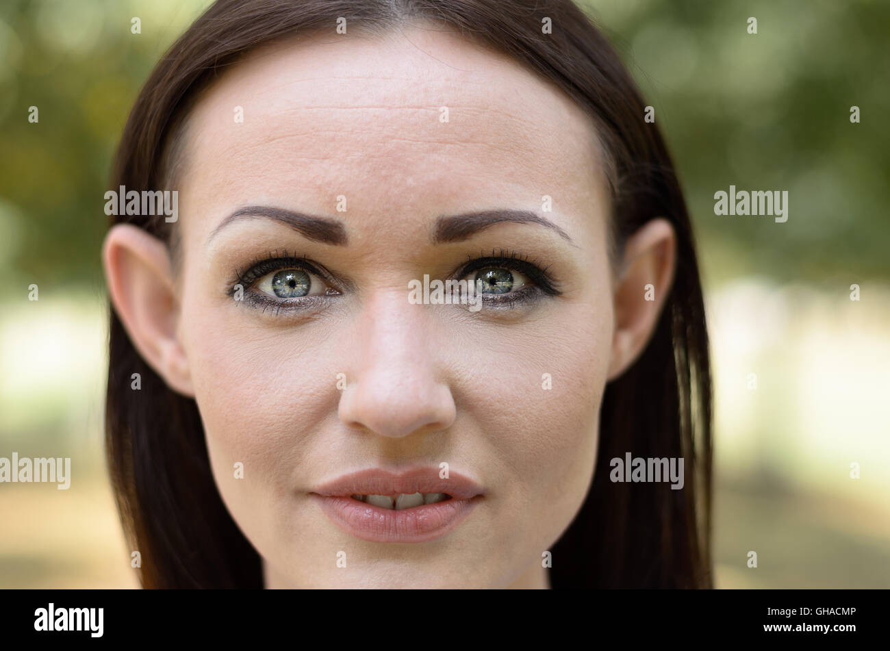 Attraktive Brünette Frau mit schönen grauen Augen und elfin Features aufmerksam in die Kamera schaut, mit geöffneten Lippen, Nahaufnahme cro Stockfoto