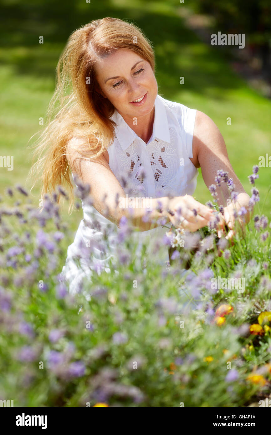 Frau trimmen Blumen im freien Stockfoto