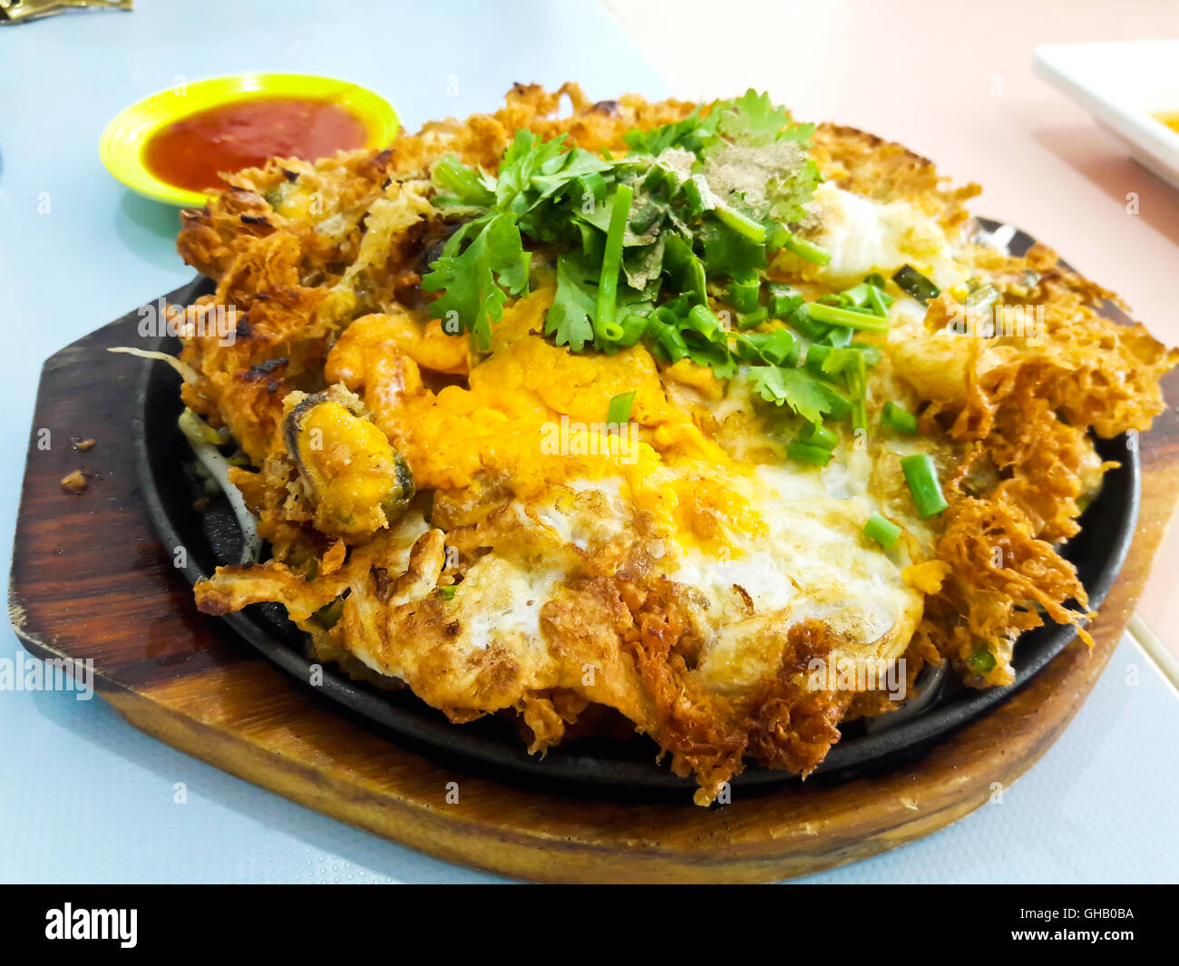 Thai-Food, gebratene Muschel Pfannkuchen in heißer Pfanne Stockfoto