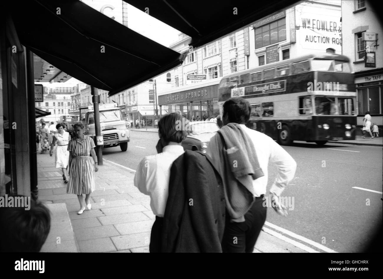 Queen Street in Cardiff c1958 Marks & Spencer zeigt, geht Bus Nr. 99 durch William Fowler Auktionsräume während ein Lieferung LKW am Straßenrand geparkt ist.  Typische Mode der Zeit während Shopper und Büroangestellte über ihr tägliches Geschäft gehen. Foto von Tony Henshaw Stockfoto