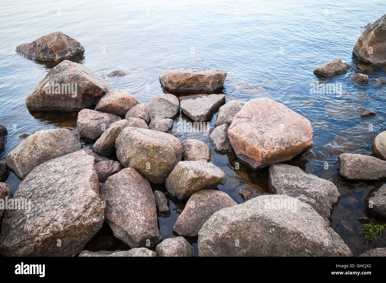 Coastal Granitsteine lag in noch Seewasser Stockfoto