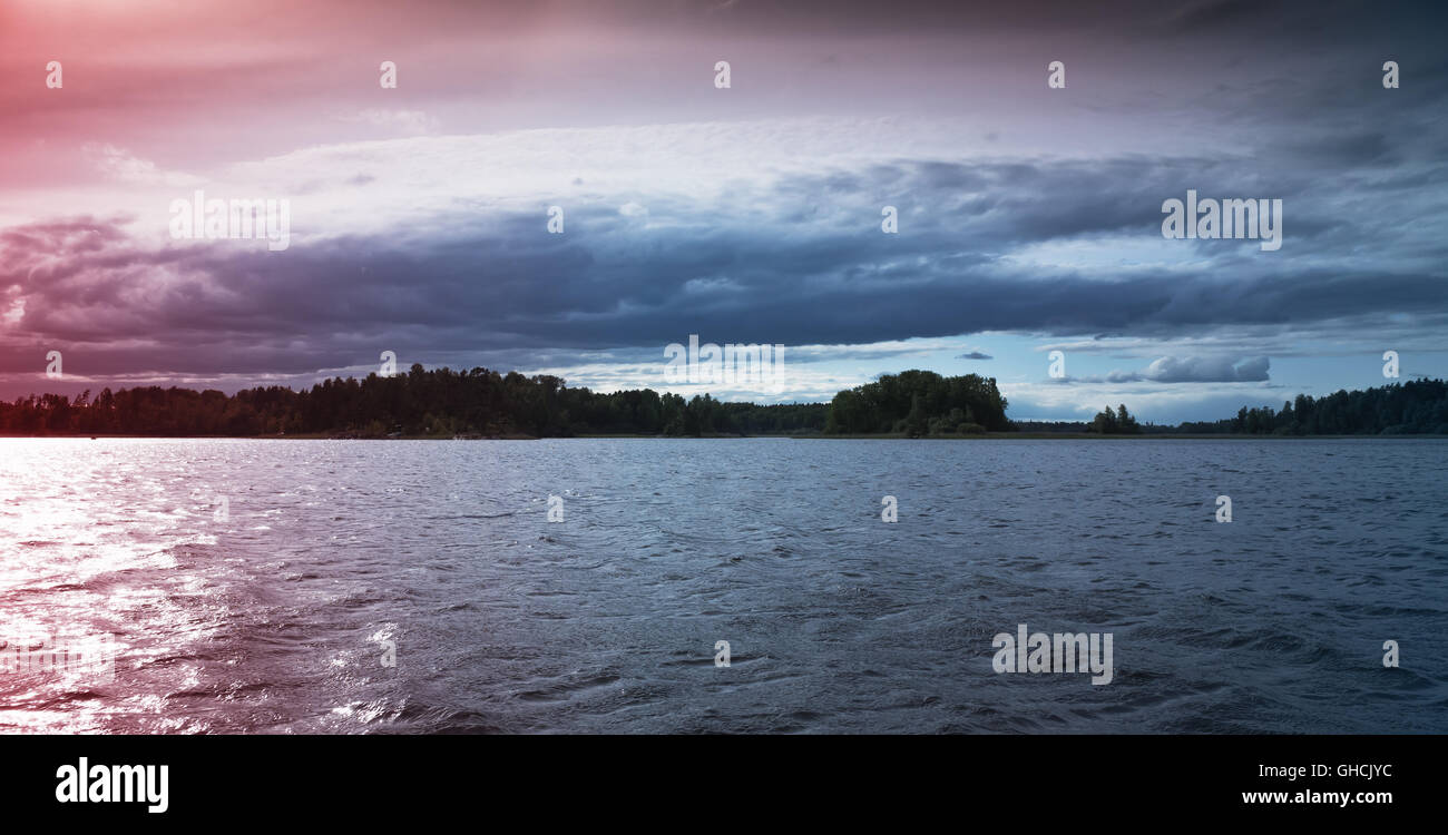 Ladoga-Seenlandschaft bei Sonnenuntergang. Tonwertkorrektur Fotoeffekt, bunte Gradienten-filter Stockfoto