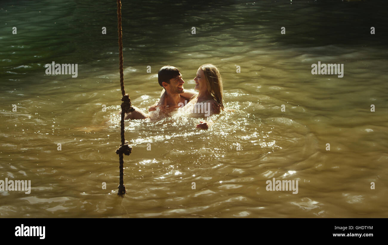 Junges Paar im sonnigen See schwimmen Stockfoto