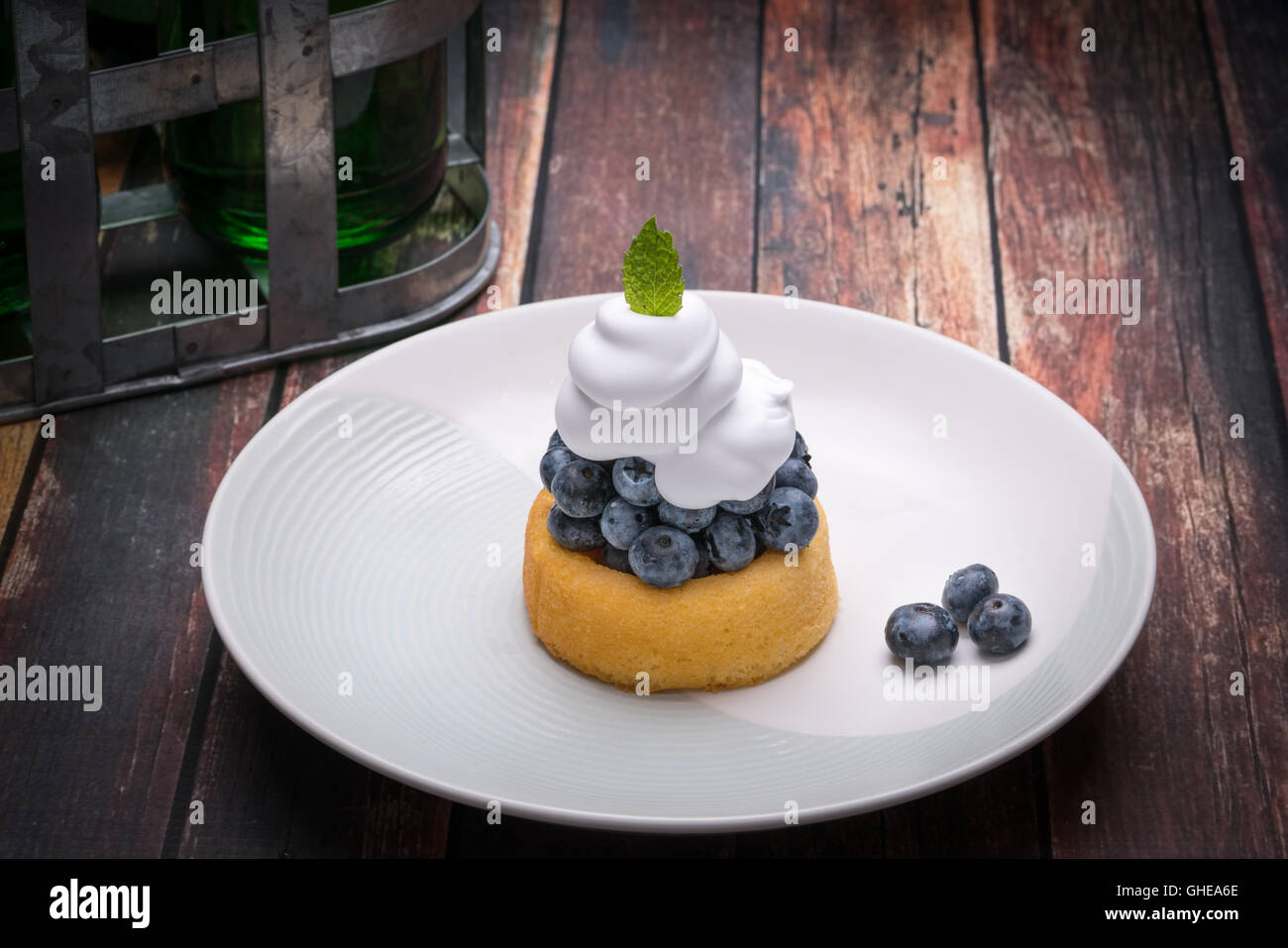 Frische Heidelbeeren auf einen kleinen Kuchen mit Schlagsahne Stockfoto