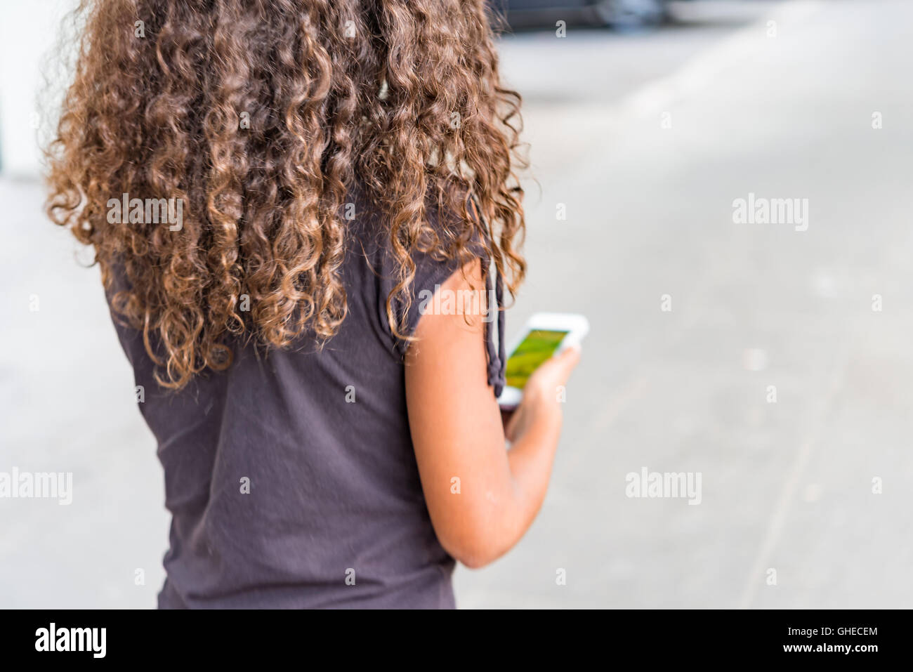 Junge Mädchen gehen auf der Straße mit Smartphone app Monster in Internet-Spiel suchen Stockfoto